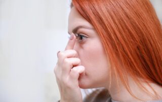 Pessoa jovem colocando a lente de contato no olho